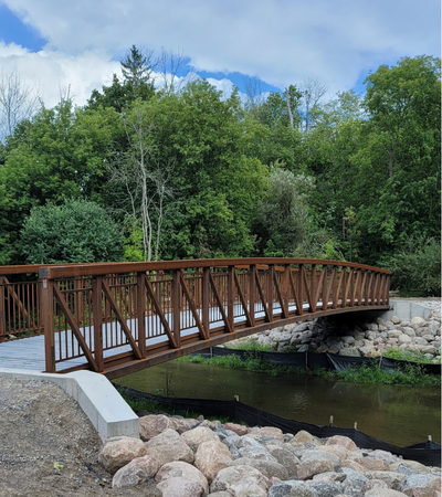 Self-weathering steel pedestrian bridge built over a waterway by Coyote Bridges